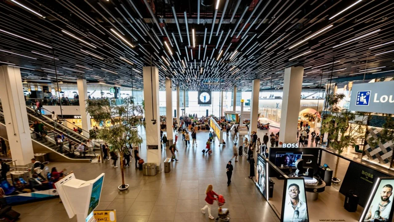 Aeroport modern cu mulți călători și zone comerciale.