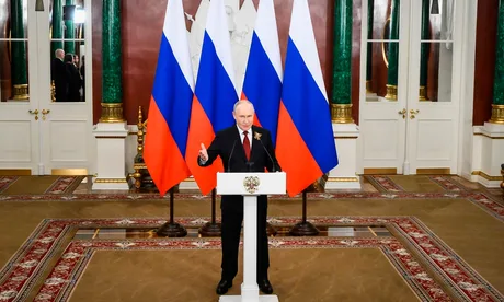 Vladimir Putin vorbește despre cooperarea economică cu China în fața drapelului rus.