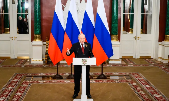 Vladimir Putin vorbește despre cooperarea economică cu China în fața drapelului rus.