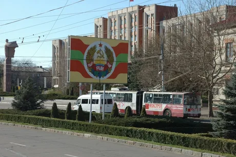 Steag și autobuze pe o stradă din Transnistria, simbol al tensiunilor geopolitice.