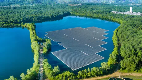 Panouri solare amplasate pe apă, reflectând natura din jur.