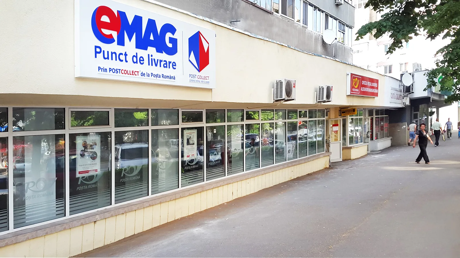 Locația unui punct de livrare eMAG, cu clienți pe trotuar.