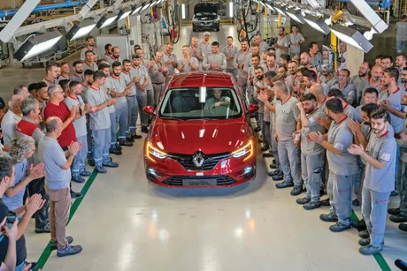 Angajați ai uzinei Renault din Bursa sărbătoresc finalizarea unei mașini noi.