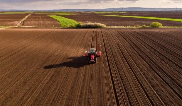 Peisaj agricol cu un tractor pe câmpuri arate în Cluj.