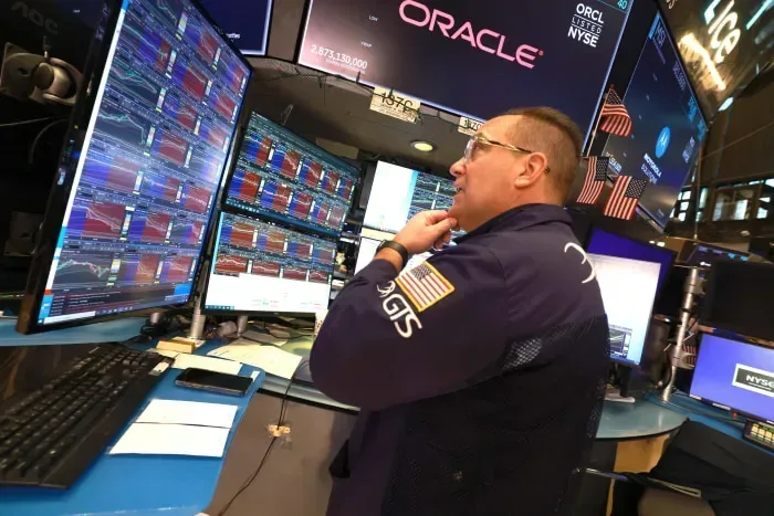 Trader analizând graficele pe piața de valori la New York.