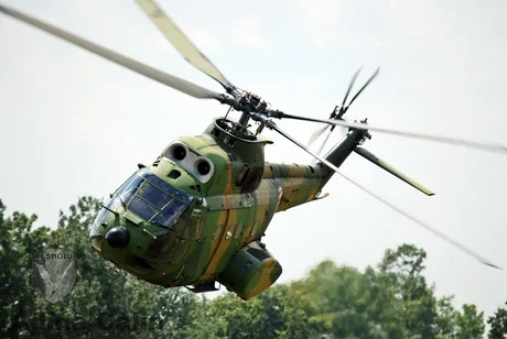 Elicopter IAR-330 în zbor, cu un design militar distinctiv.