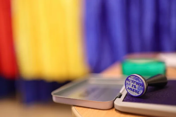 Un ștampila pe o masă, cu fundal colorat în galben și albastru.