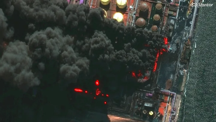 Fum gros se ridică de la instalațiile portuare afectate.