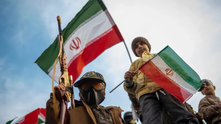 Copii iranieni cu steaguri naționale, implicați în recrutare militară.