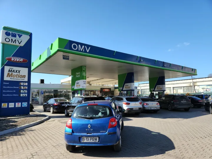 Stație de alimentare cu carburanți aglomerată în România, cu mașini așteptând la rând.