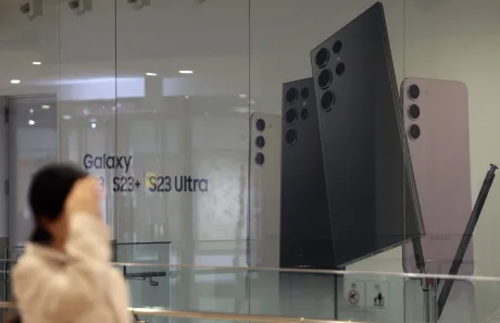 O persoană observă un panou publicitar cu telefoane Samsung Galaxy.