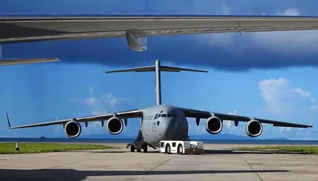 Aeronave militare parcate pe un aeroport, sub un cer senin.