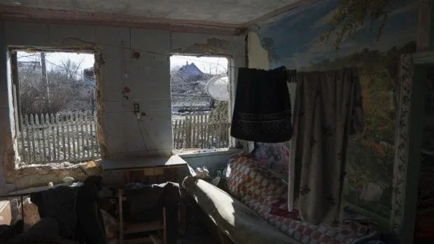 Interior distrus al unei case, cu feronerie și perdele deteriorate.
