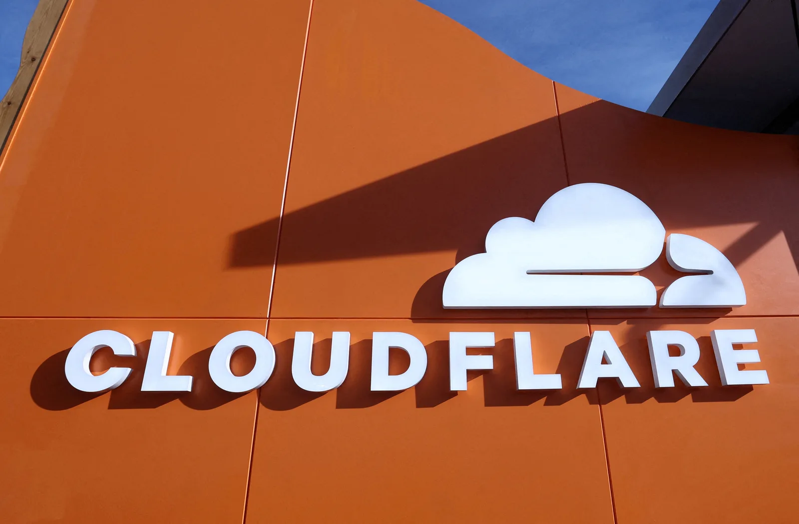 Logo-ul Cloudflare pe un fundal portocalie, simbolizând securitatea online.
