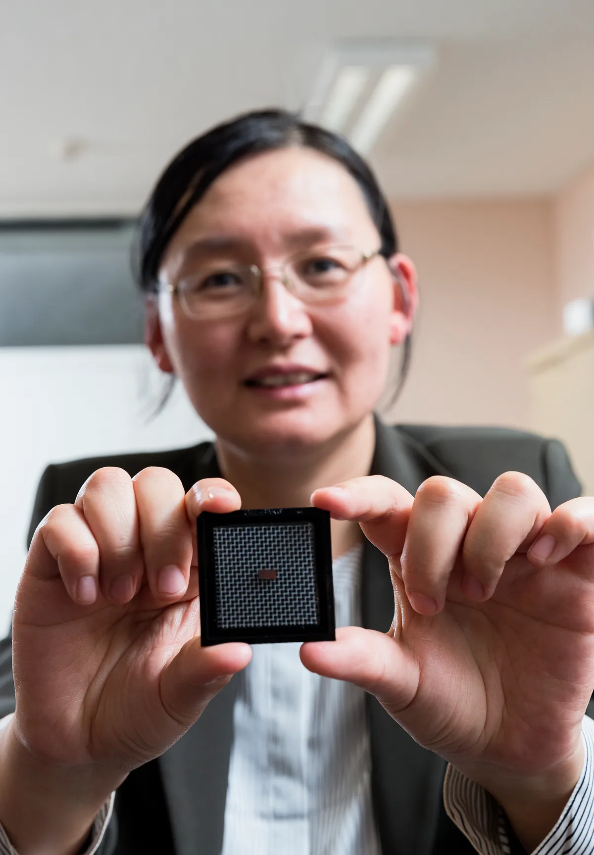 Cercetător prezentând cipul fotonic dezvoltat la Universitatea din Sydney.