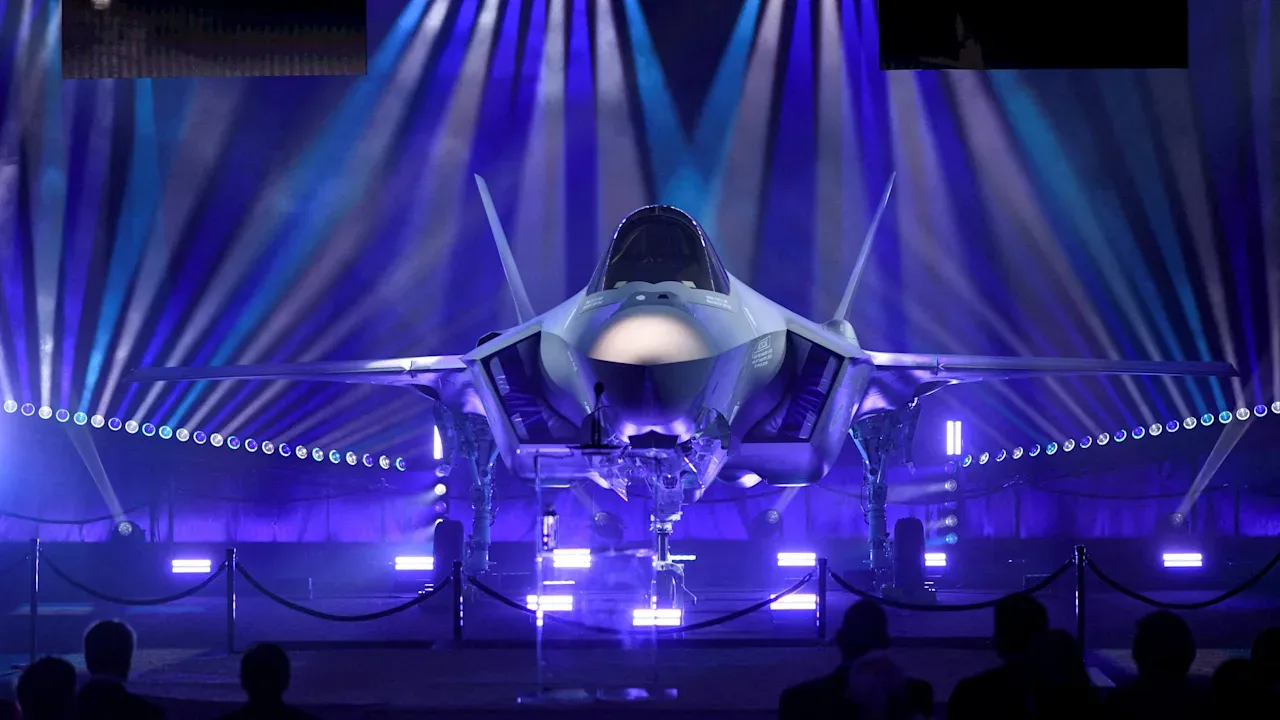 Avion de luptă F-35A expus în lumini colorate, simbol al puterii militare.