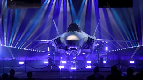 Avion de luptă F-35A expus în lumini colorate, simbol al puterii militare.