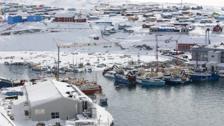 Vedere panoramică a unui port din Groenlanda, plin de bărci.