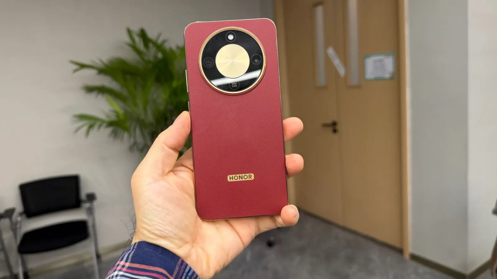 Smartphone HONOR Magic 8 Lite într-o nuanță roșie, prezentat în mână.