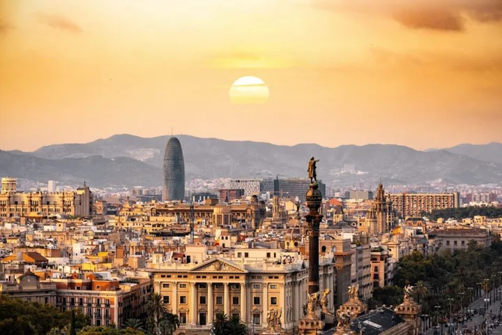 Peisaj urban din Barcelona la apus, evidențiind arhitectura și natura.
