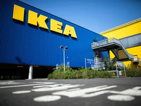 Clădirea IKEA cu fațada albastră și galbenă, parcarea din față.