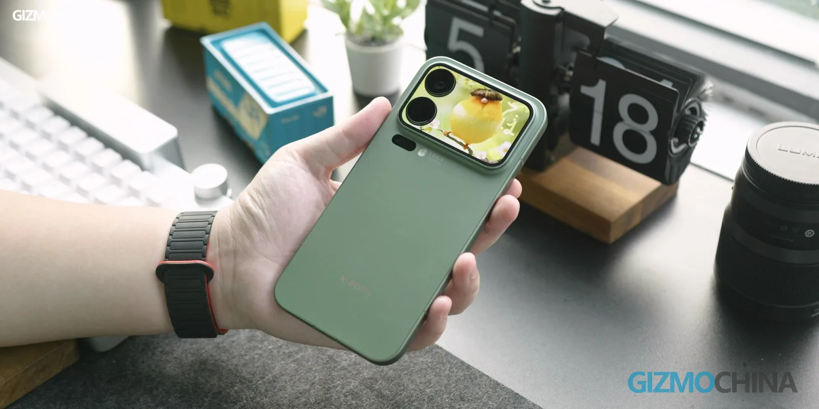 Un smartphone verde cu un ecran secundar pe spate, având un design modern.