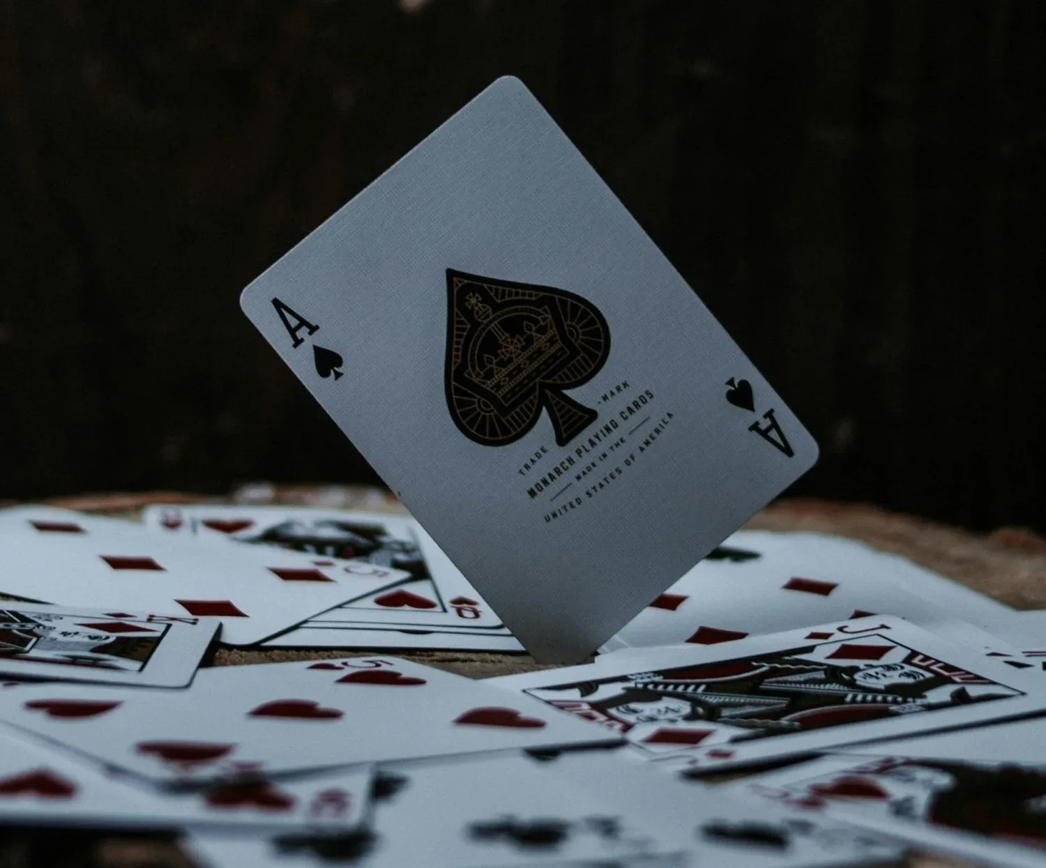 Cărți de joc aranjate pe o masă, cu un as de spade în prim-plan.