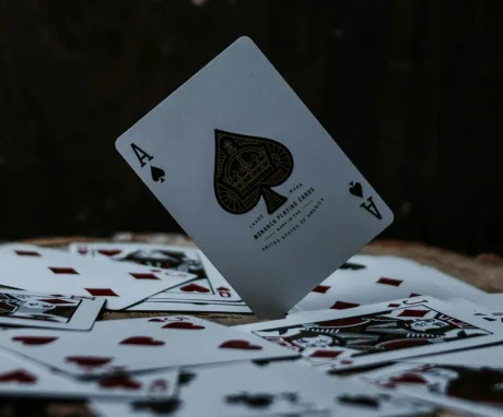 Cărți de joc aranjate pe o masă, cu un as de spade în prim-plan.