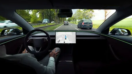 Tesla FSD în acțiune pe drum, cu șoferul pregătit să intervină.