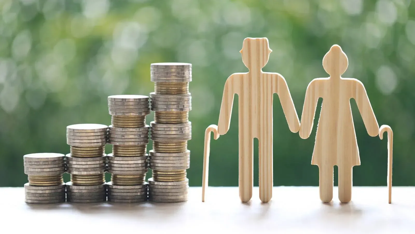 Pereche de pensionari lângă monede, simbolizând economiile pentru pensii.