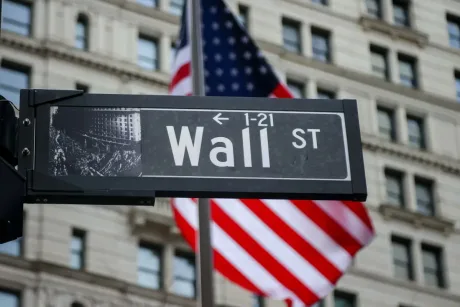 Strada Wall Street cu steagul american în fundal.