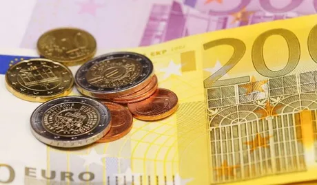 Monede și bancnote euro, simbolizând salariile din construcții.