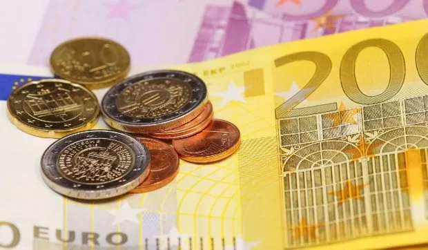 Monede și bancnote euro, simbolizând salariile din construcții.