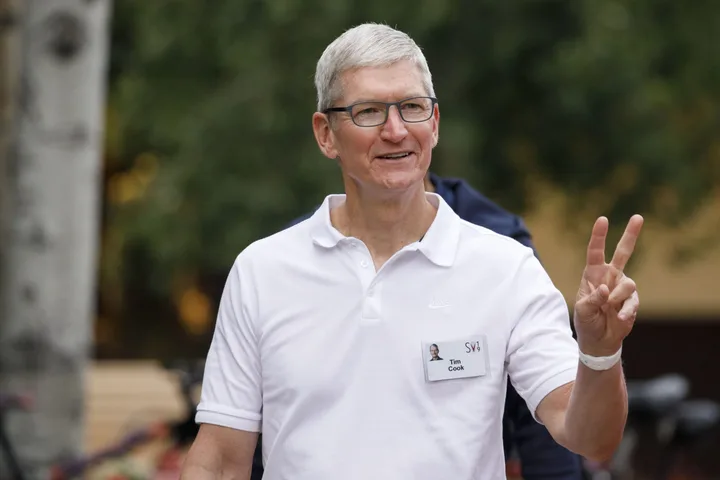 Tim Cook zâmbind și făcând semnul păcii în aer liber.