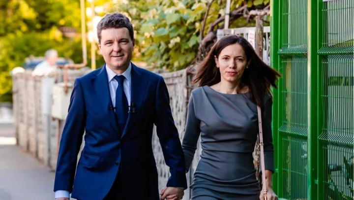 Mirabela Grădinaru și soțul ei, îmbrăcați elegant, pe o stradă din oraș.