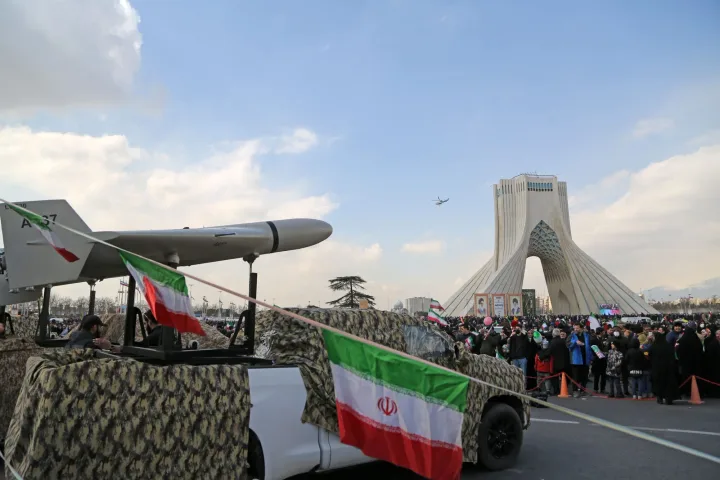Protest în Iran cu rachete și steaguri naționale, simbolizând tensiunile regionale.