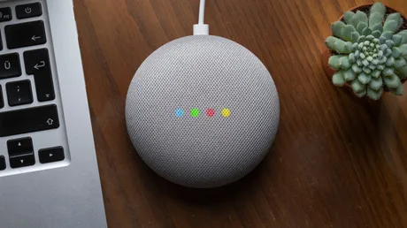 Dispozitiv Google Home pe birou, pregătit pentru comenzi vocale.