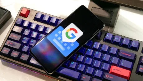 Un telefon cu logo Google pe o tastatură mecanică colorată.