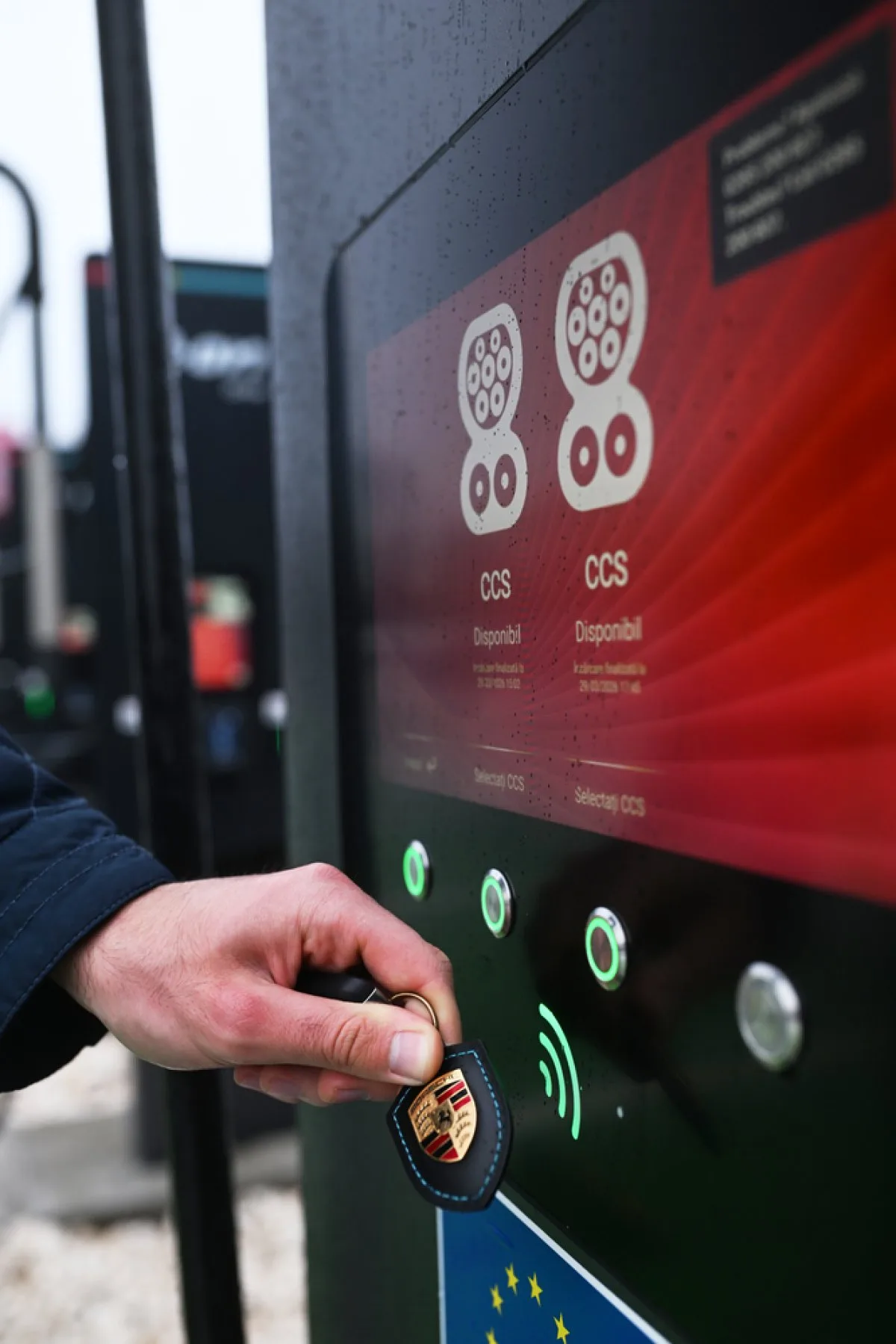 Utilizator activând o stație de încărcare Porsche.