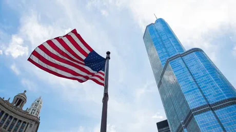 Steagul Statelor Unite fluturând lângă o clădire modernă în oraș.