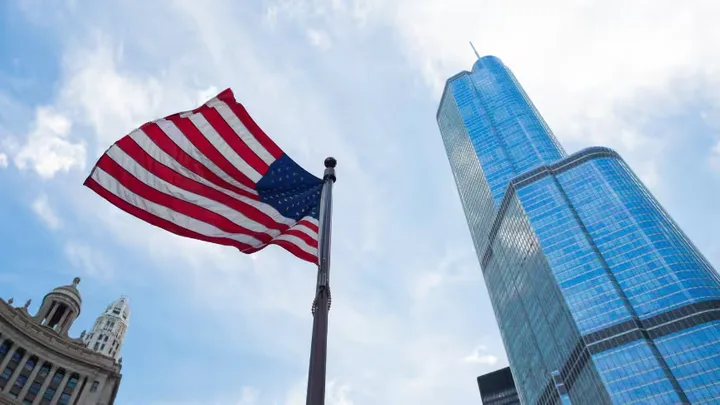 Steagul Statelor Unite fluturând lângă o clădire modernă în oraș.