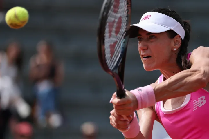 Sorana Cîrstea pregătindu-se să lovească mingea de tenis.
