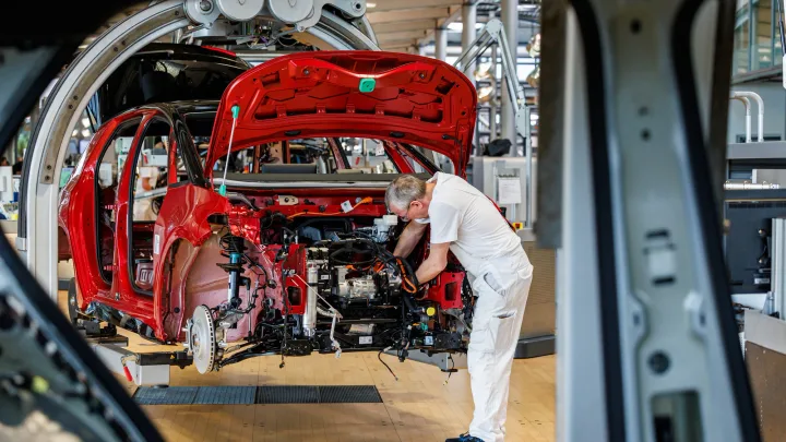 Un muncitor asamblează un automobil într-o fabrică din Brazilia.
