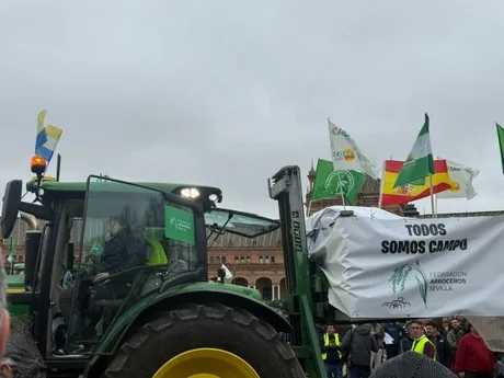 Tractor cu steaguri și banner la o manifestație agricolă în Sevilla.