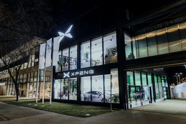 Reprezentanța Xpeng din România, cu un design modern și iluminat nocturn.