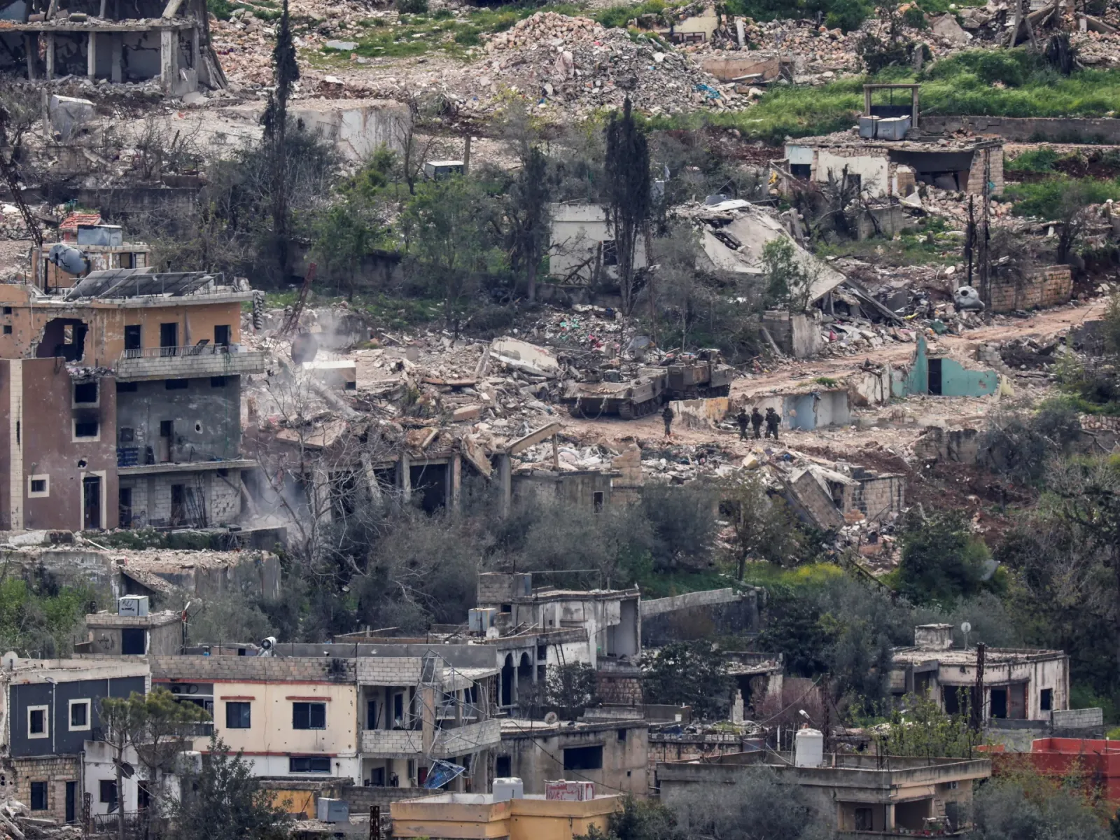 Peisaj devastat de război, clădiri distruse și vegetație afectată.