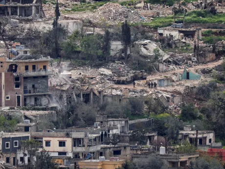 Peisaj devastat de război, clădiri distruse și vegetație afectată.