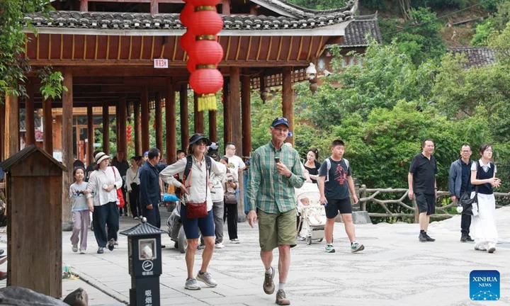 Turiști străini explorând un sat tradițional din China.