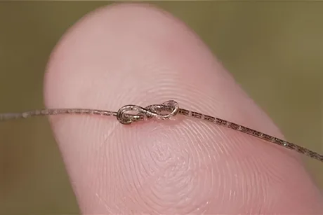 Cip pe fibră subțire, integrat pe un deget, demonstrând tehnologia avansată.