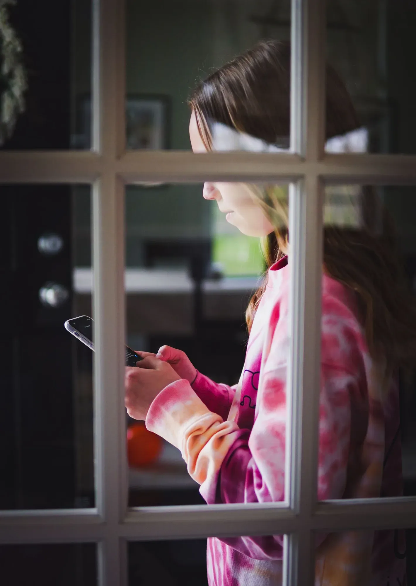 Fată folosind un smartphone, privind atent la ecran.